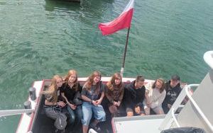 Grupa uczniów siedzących na rufie statku wycieczkowego